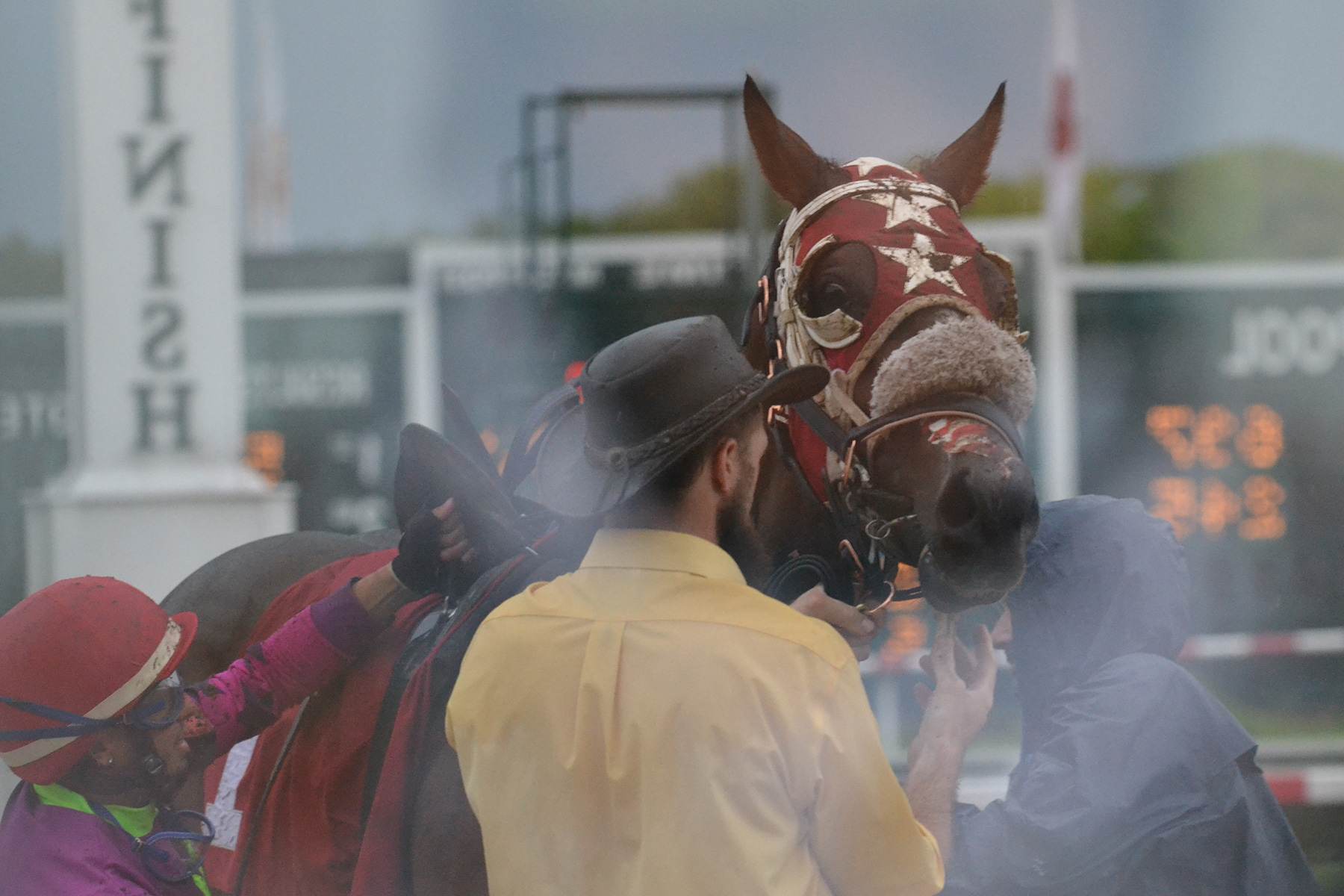 Unsaddling after the sixth race, as reflected in the scale house window